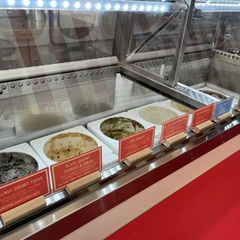 Oddfellows - Multiple ice cream flavors are shown in a glass display case, each with a label, at an ice cream parlor. - Ice Cream & Frozen Yogurt Near Me - Spring, Texas