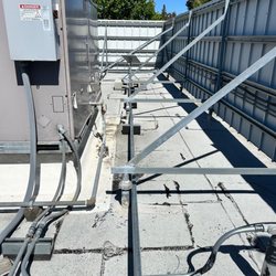 The Remo Group - Starlink Performance Gen3 Enterprise Antenna Installation on Commercial Building Rooftop with Metal Conduits and Rooftop Support Blocks.