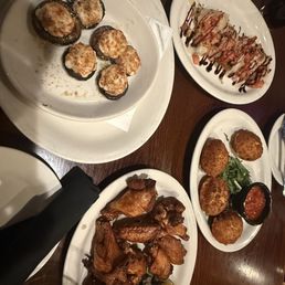 Stuffed mushrooms, chicken wings, stuffed ravioli, and bruschetta appetizers