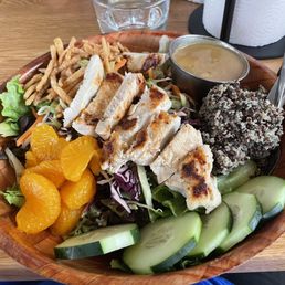 a salad with chicken, oranges, cucumbers, and french fries a salad with chicken, oranges, cucumbers, and french fries