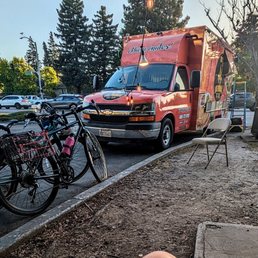 the truck, with lighting and chairs nearby the truck, with lighting and chairs nearby
