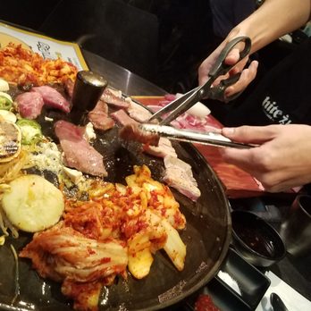 Honey Pig BBQ - Server grilling and slicing the meat - Korean Near Me - Irvine, California Honey Pig BBQ - Server grilling and slicing the meat - Korean Near Me - Irvine, California