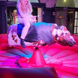 a woman riding a fake cow