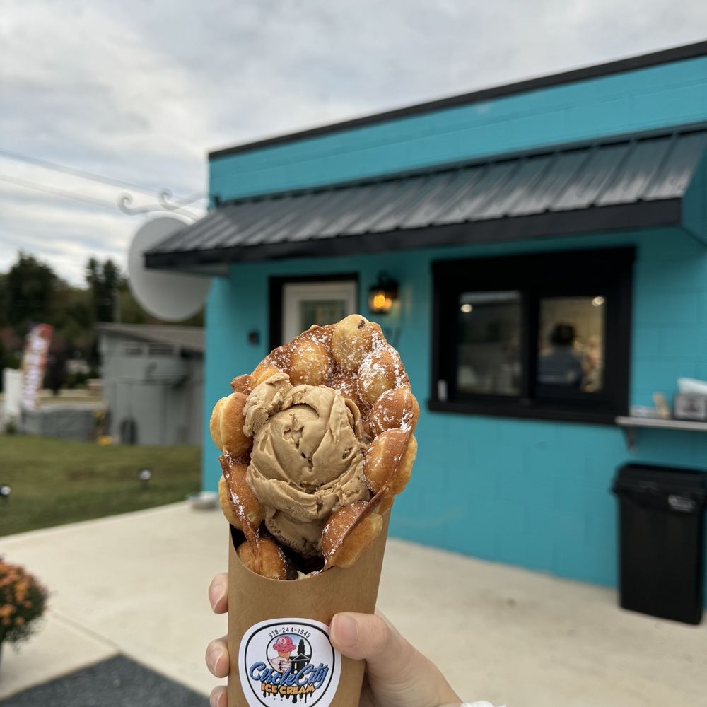 a hand holding a cone of ice cream a hand holding a cone of ice cream