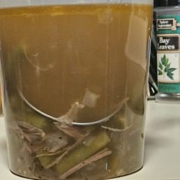 Green beans in water topped with grease.