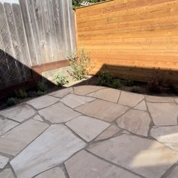 a stone patio with a wooden fence a stone patio with a wooden fence