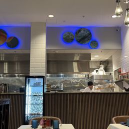 Set tables, dessert fridge, and cooking area. Set tables, dessert fridge, and cooking area.