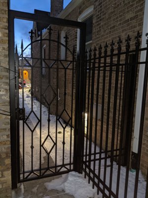 Norwood Park Fence and Custom design gate - Created a combination cedar wood and iron bar fence, with client custom designed iron gate!
This was a special project, using 3" posts, 3/4" solid bars and special order finials. Cedar wood boards installed between bars for added privacy in the yard. Created a beautiful, private and secure space for the client's backyard. We hope they enjoy it all year long! Norwood Park Fence and Custom design gate - Created a combination cedar wood and iron bar fence, with client custom designed iron gate!
This was a special project, using 3" posts, 3/4" solid bars and special order finials. Cedar wood boards installed between bars for added privacy in the yard. Created a beautiful, private and secure space for the client's backyard. We hope they enjoy it all year long!