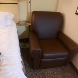 Recliner stuffed into narrow space by head off bed. Difficult to get around/in and out of bed on that side. All outlets on opposite side. Recliner stuffed into narrow space by head off bed. Difficult to get around/in and out of bed on that side. All outlets on opposite side.