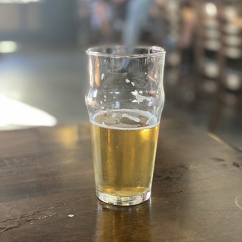 The Growler - a glass of beer on a table - New American Near Me - Danville, California The Growler - a glass of beer on a table - New American Near Me - Danville, California