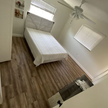 Mitzora Flooring - a bedroom with a bed and a ceiling fan - Flooring Near Me