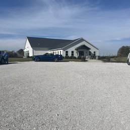 a white barn and a blue car