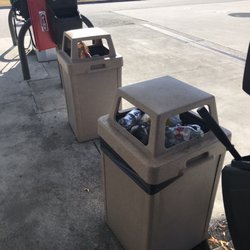 7-Eleven - Trash cans over flowing outside, trash in parking lot.