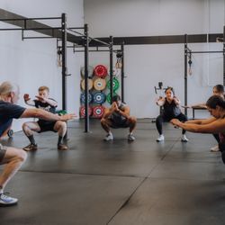 Transform Fitness - "A coach leads a group warm-up, with members following along on the gym floor."
