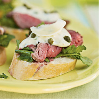 The FoodSmiths Catering - Sliced tenderloin atop a baguette slice with arugula, citrus aioli, capers, and a parmesan shaving. - Caterers Near Me - Dublin, Ohio The FoodSmiths Catering - Sliced tenderloin atop a baguette slice with arugula, citrus aioli, capers, and a parmesan shaving. - Caterers Near Me - Dublin, Ohio