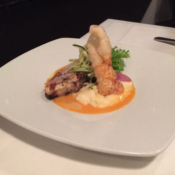 Global Grill - Seared wahoo on top of grits, topped with pickled cucumber and a single pork rind, dressed with hot sauce. - New American Near Me - Pensacola, Florida Global Grill - Seared wahoo on top of grits, topped with pickled cucumber and a single pork rind, dressed with hot sauce. - New American Near Me - Pensacola, Florida