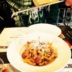 Spaghetti House - Parmesan being grated above yummy egg pasta with sausage