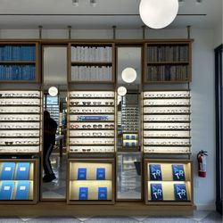 Warby Parker Addison - Cute bookcases with books and frames displayed.