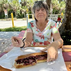 Monica, smiling with that beautiful corned beef and pastrami Reuben sandwich