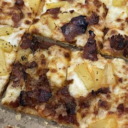 a pizza with pineapples and bacon