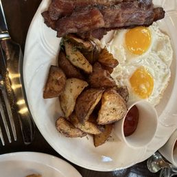 Two eggs and bacon with breakfast potatoes and sourdough toast.