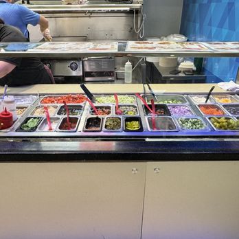Greek Cuisine - a woman preparing food in a restaurant - Greek Near Me - Raleigh, North Carolina Greek Cuisine - a woman preparing food in a restaurant - Greek Near Me - Raleigh, North Carolina