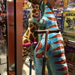 Learning Express Toys - Such a cute window display, a T-Rex and a giraffe hugging.