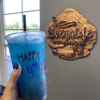 Riverside Nutrition - a hand holding a blue drink - Juice Bars & Smoothies Near Me - Clearwater, Minnesota Riverside Nutrition - a hand holding a blue drink - Juice Bars & Smoothies Near Me - Clearwater, Minnesota