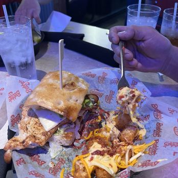 Bubba's 33 - Bacon avocado chicken sandwich - A bacon avocado chicken sandwich with lettuce, tomato, and cheese on a bun, served with seasoned fries topped with cheese and bacon, on a tray at a casual dining restaurant. - American Near Me - Las Cruces, New Mexico