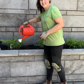 The Chinook Gardener - a woman holding a red watering can - Landscaping Near Me - Calgary, Alberta The Chinook Gardener - a woman holding a red watering can - Landscaping Near Me - Calgary, Alberta