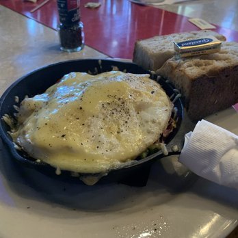 The Laundry - Skillet breakfast (Benedict) with hollandaise sauce and a chunk of crusty homemade bread - New American Near Me - Fenton, Michigan