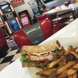 Foreground: Smoked turkey sandwich Background: jukebox and some diner memorabilia Foreground: Smoked turkey sandwich Background: jukebox and some diner memorabilia