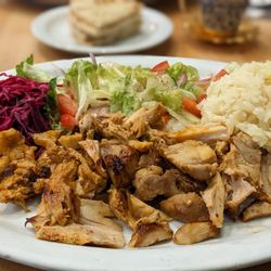 Mediterranean Kebab - Chicken Gyros Plate with pickled cabbage, salad, mediterraneean rice and a side of yogurt sauce (?). Pita bread (in background).