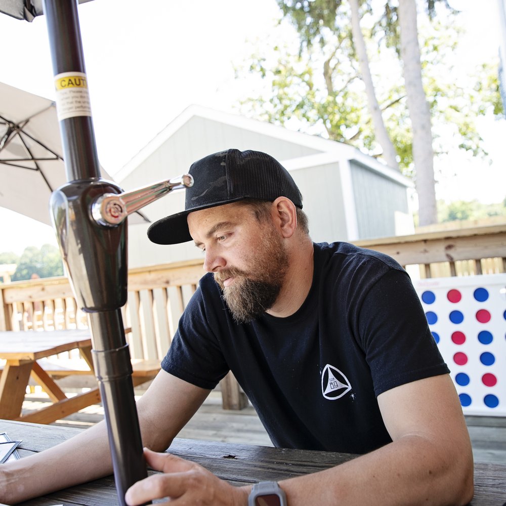 Brew Link Brewing - The Husband looking over the menu with a cool outdoor game behind him. - Breweries Near Me - Plainfield, Indiana