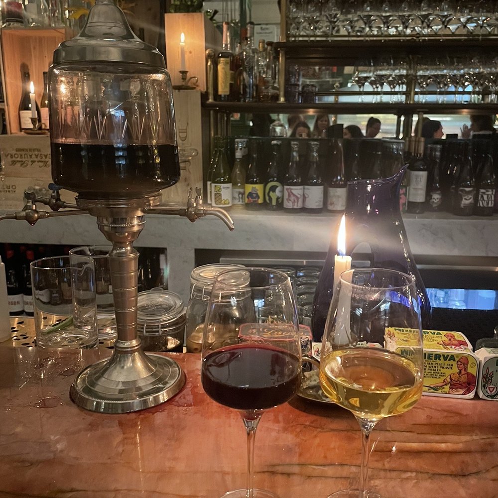 two glasses of wine on a bar