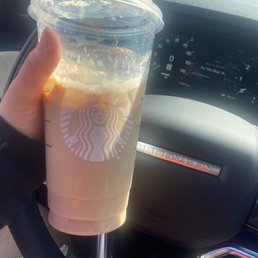 a hand holding a cup of iced coffee