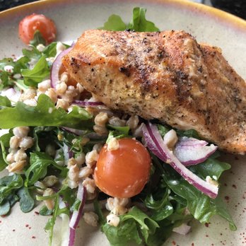 Curio Bistro - Salmon on a bed of lightly seasoned arugula with tomato salad. Love the flavors and cooked to my liking.  Grilled Atlantic Salmon - Cajun/Creole Near Me - New Orleans, Louisiana