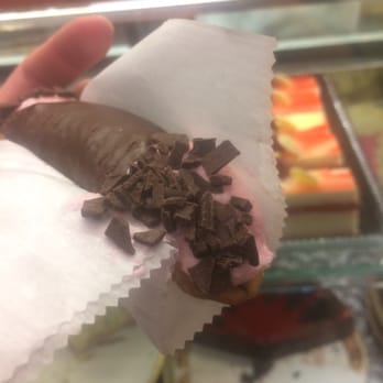 Cake Royale - a hand holding a chocolate covered donut - Bakeries Near Me - Cleveland, Ohio