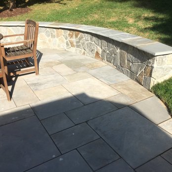 Rafael's Landscaping - a view of a patio with a bench and a stone wall - Landscaping Near Me Rafael's Landscaping - a view of a patio with a bench and a stone wall - Landscaping Near Me