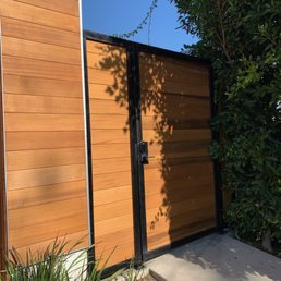 Black metal and cedar plant pedestrian gate