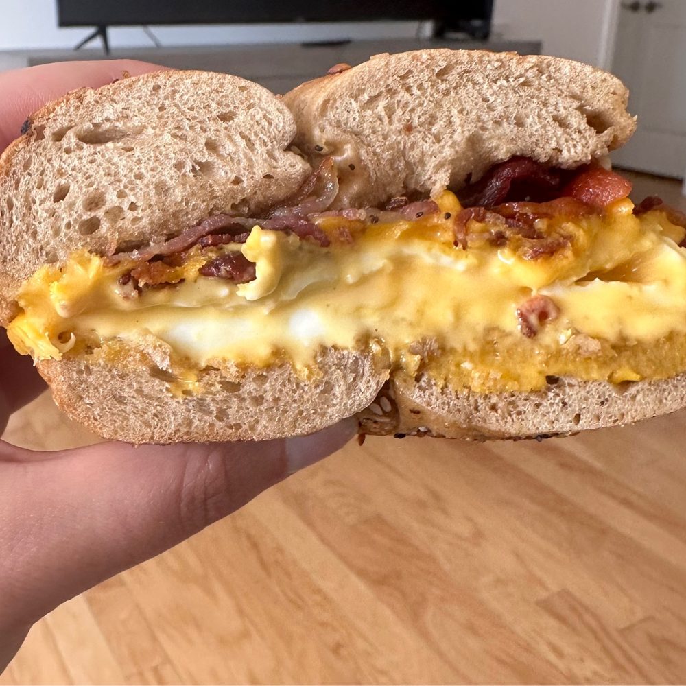 a hand holding a breakfast sandwich a hand holding a breakfast sandwich