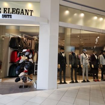 Mens Elegant Suits - The image shows the exterior of Mens Elegant Suits, a clothing store in a shopping mall, with mannequins dressed in suits and a display of hats. - Men's Clothing Near Me - Rosemont, Illinois