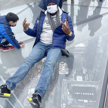 One World Observatory - My husband sitting on the top of the glass building 100 feet up - Observatories Near Me - New York, New York