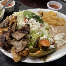 Cheese enchiladas with grilled steak and chicken on top Cheese enchiladas with grilled steak and chicken on top