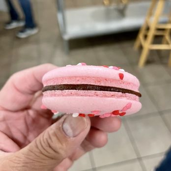 Baking Arts & Coffee - a hand holding a pink macaron - Cooking Schools Near Me - San Mateo, California Baking Arts & Coffee - a hand holding a pink macaron - Cooking Schools Near Me - San Mateo, California