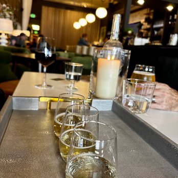 Sips on Main - a row of glasses on a table - Wine Bars Near Me - Cedaredge, Colorado