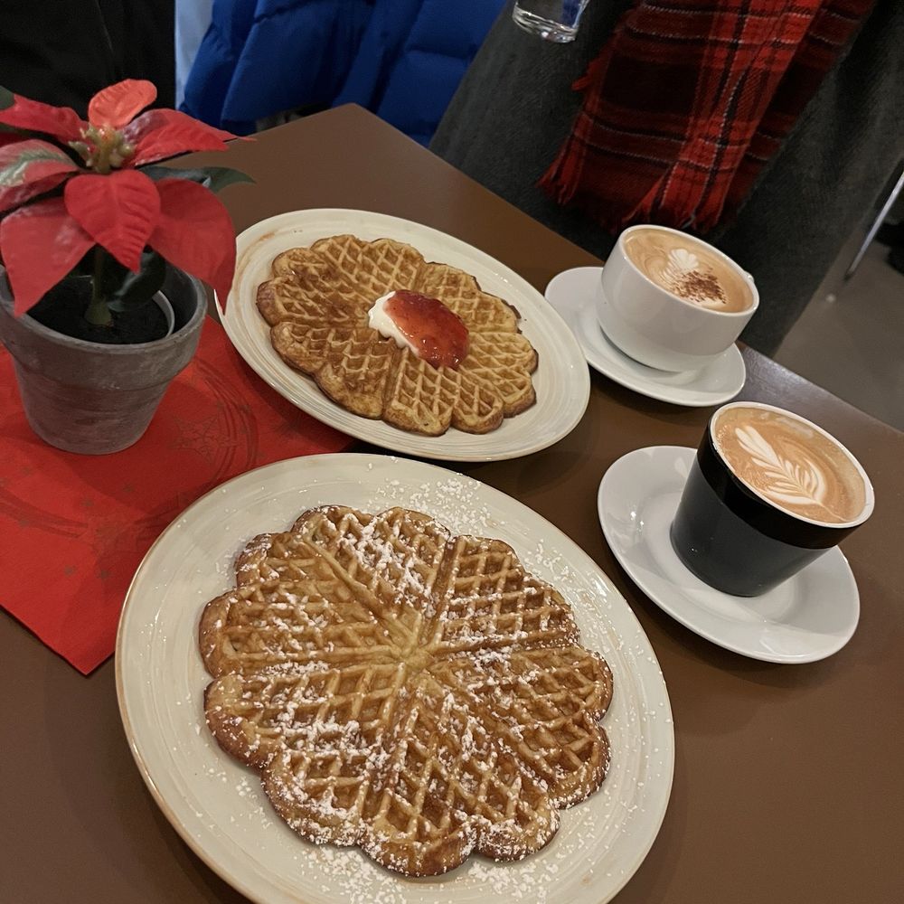 Dirty chai, late, and two waffles: one with powdered sugar and the other with sour cream and strawberry jam Dirty chai, late, and two waffles: one with powdered sugar and the other with sour cream and strawberry jam