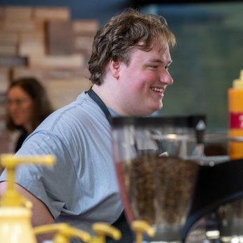 Awaken Coffee - a smiling man in a coffee shop - Coffee & Tea Near Me - Greenville, North Carolina Awaken Coffee - a smiling man in a coffee shop - Coffee & Tea Near Me - Greenville, North Carolina
