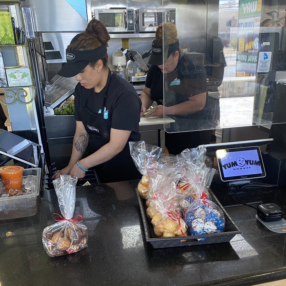 Two staff members counting the cash drawers, one of which is on a cutting board where food is prepped. Two staff members counting the cash drawers, one of which is on a cutting board where food is prepped.