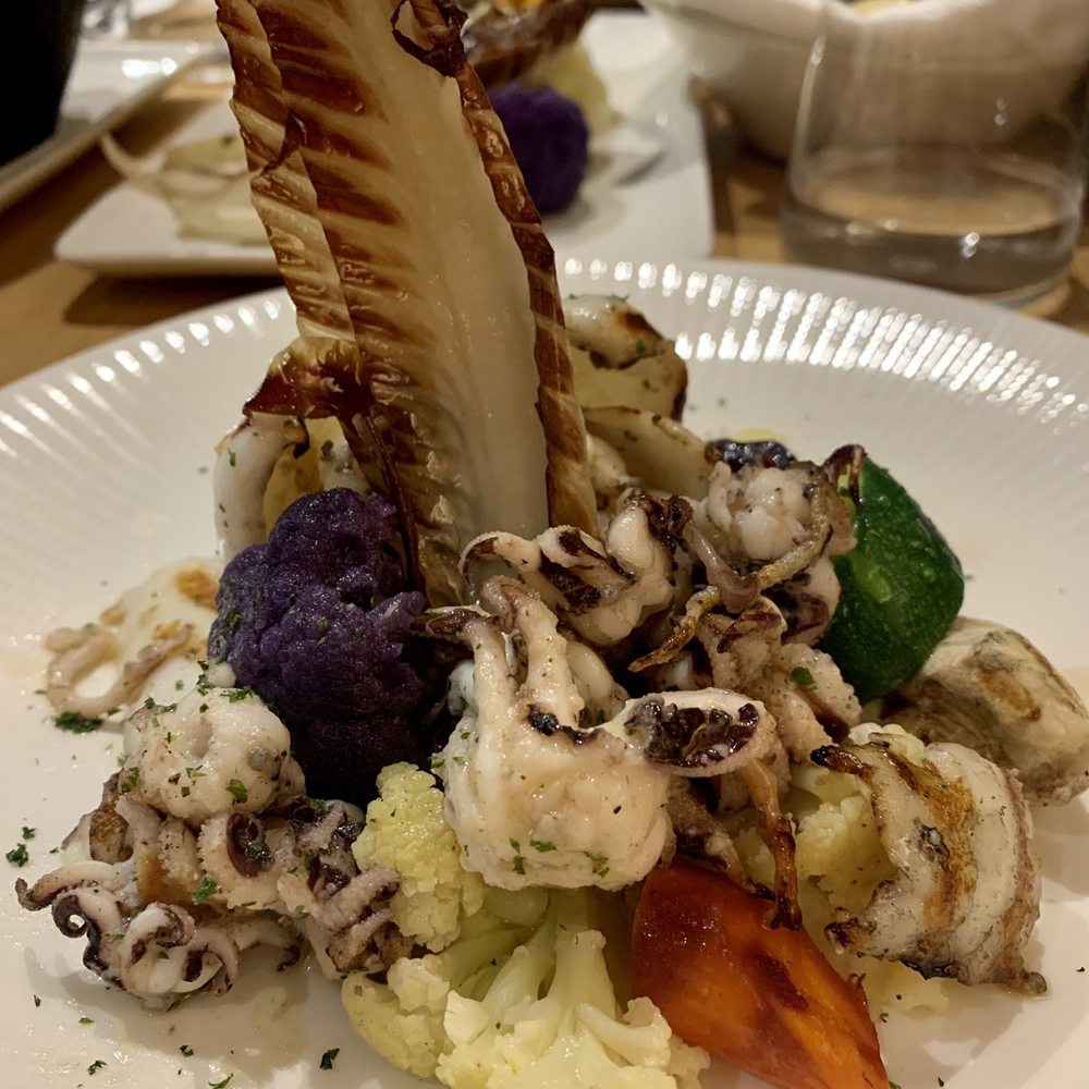 Octopus on top of mashed potatoes with vegetables